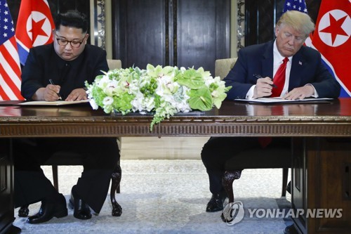 공동합의문에 서명하는 트럼프와 김정은(왼쪽)