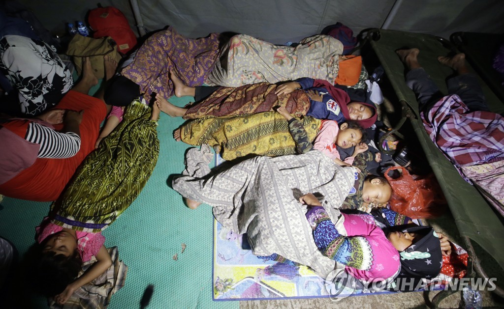 2018년 12월 23일 밤 인도네시아 순다해협에 면한 탄중 르숭 해변 인근 고지대에 마련된 피난처에서 쓰나미에 몸을 피한 주민들이 잠을 청하고 있다. [AP=연합뉴스]