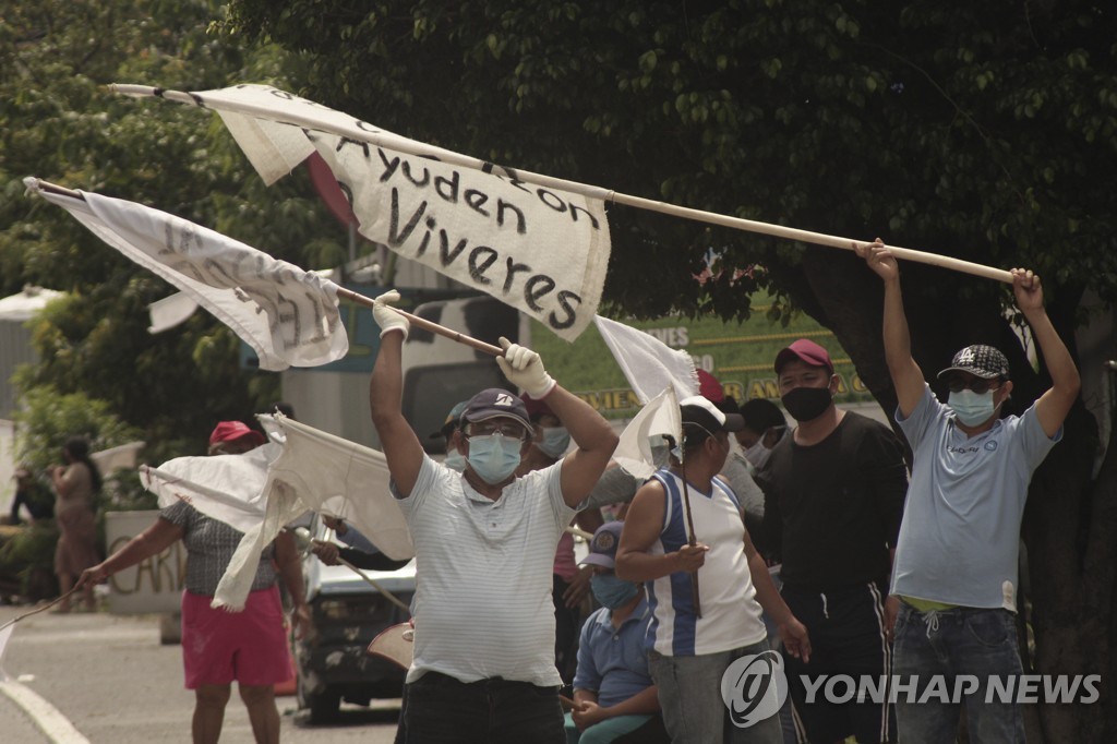 엘살바도르 빈민들이 지나는 차량을 향해 식량 지원을 호소하는 흰 깃발을 흔들고 있다.