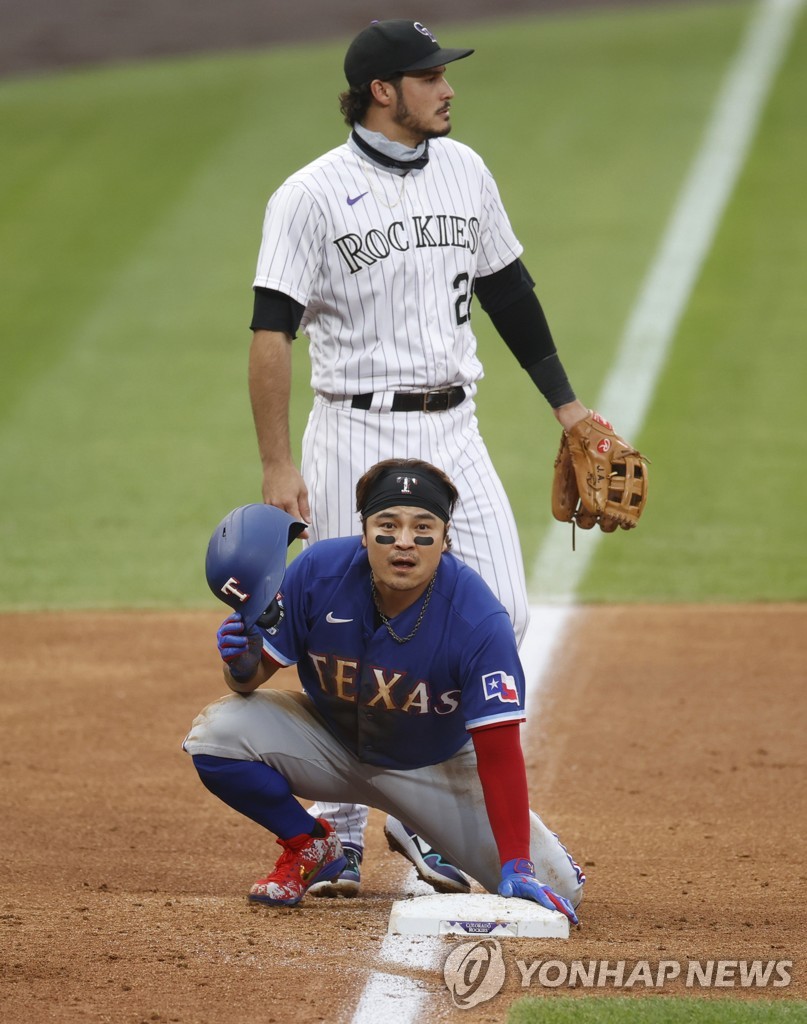 In this Associated Press file photo from Aug. 15, 2020, Choo Shin-soo of the Texas Rangers (front) takes off his helmet after stealing third base during a Major League Baseball regular season game against the Colorado Rockies at Coors Field in Denver. (Yonhap)