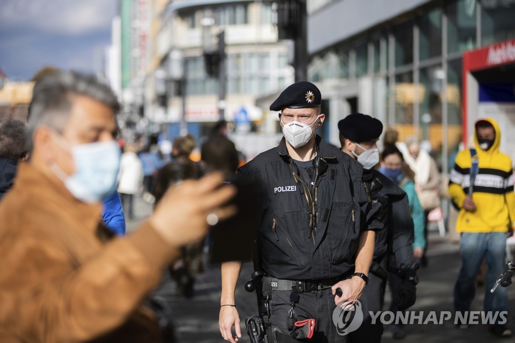 24일 베를린 빌머스도르퍼 거리에서 마스크 착용 위반을 살펴보는 경찰 [AP=연합뉴스] 