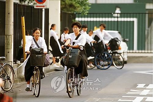 한복으로 된 교복을 입고 자전거를 타고 집으로 돌아가는 재일 조총련계 여학생들.(1994년 자료사진)