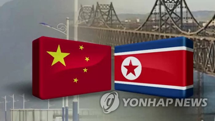An image, provided by Yonhap News TV, of the Chinese and North Korean flags with the Yalu River railroad bridge in the background. (PHOTO NOT FOR SALE) (Yonhap)