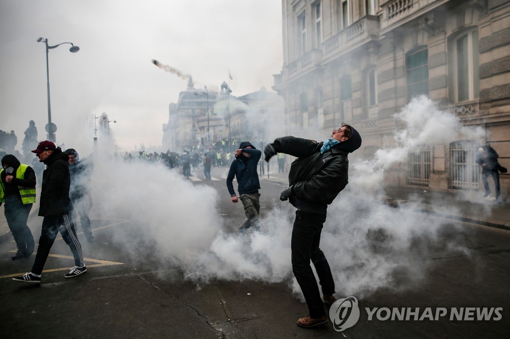 5일(현지시간) 프랑스 파리에서 열린 '노란 조끼' 시위에서 한 참가자가 물체를 던지고 있다. [AFP=연합뉴스]