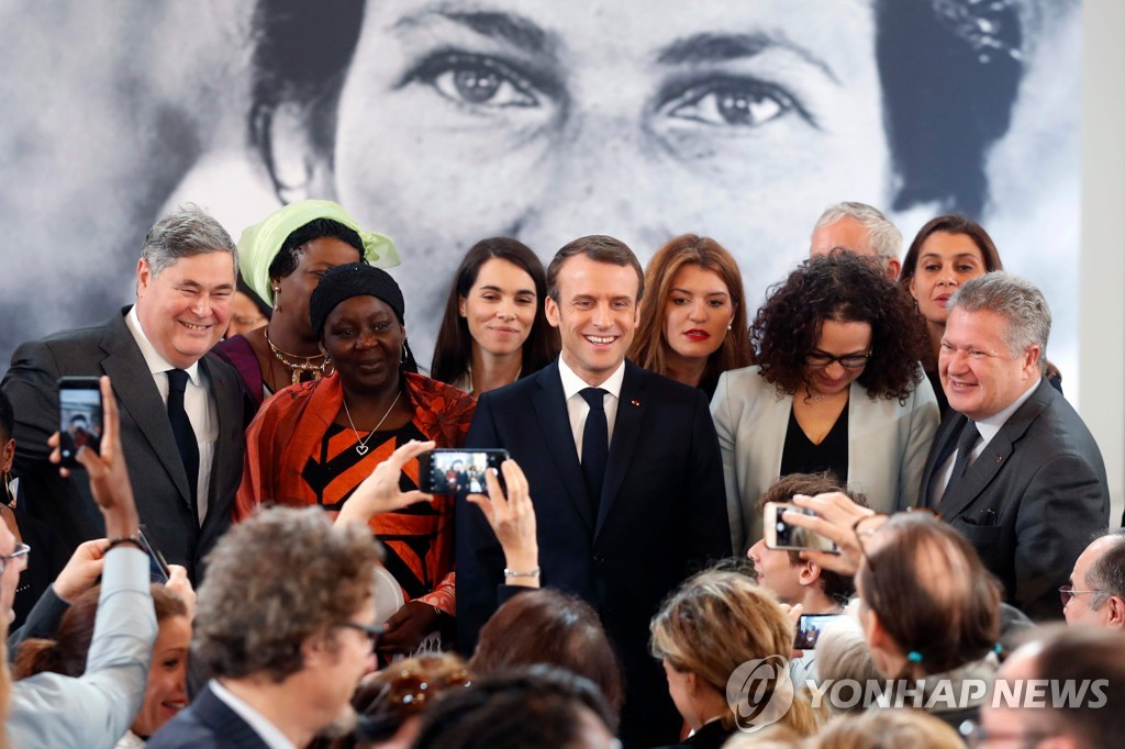 프랑스 파리 엘리제궁에서 에마뉘엘 마크롱 대통령(가운데)이 '시몬 베이' 상을 카메룬의 여성운동가 아이사 두마라(왼쪽에서 두번째)에게 시상한 뒤 기념촬영을 하며 웃고 있다. [AFP=연합뉴스]