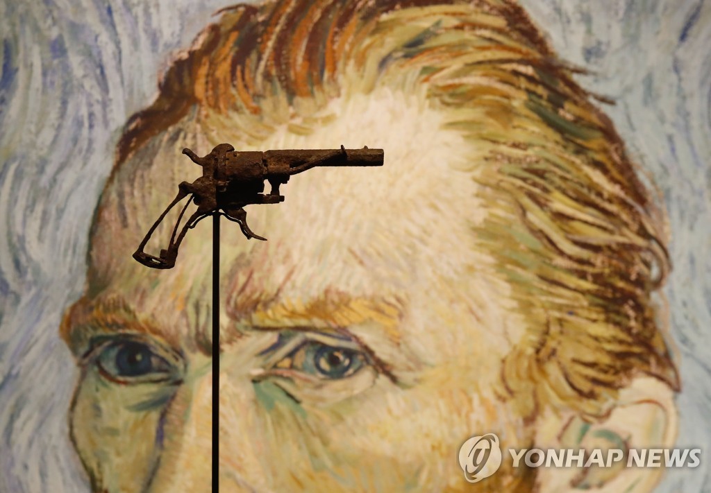 지난 14일 프랑스 파리의 경매장에 반 고흐의 자화상을 배경으로 전시된 문제의 권총 [AFP=연합뉴스]