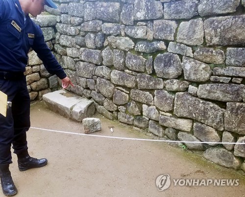 태양의 신전 내에서 떨어진 돌 파편 가리키는 경찰
