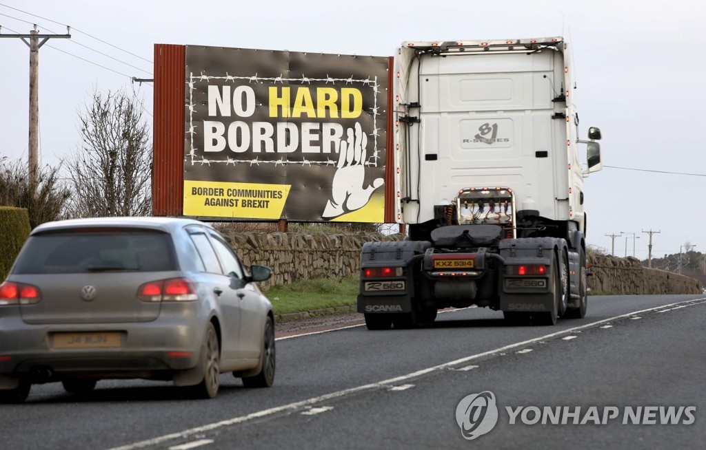  이달 1일 아일랜드와 북아일랜드 국경의 '물리적 국경 반대' 입간판 옆을 지나는 차량들
