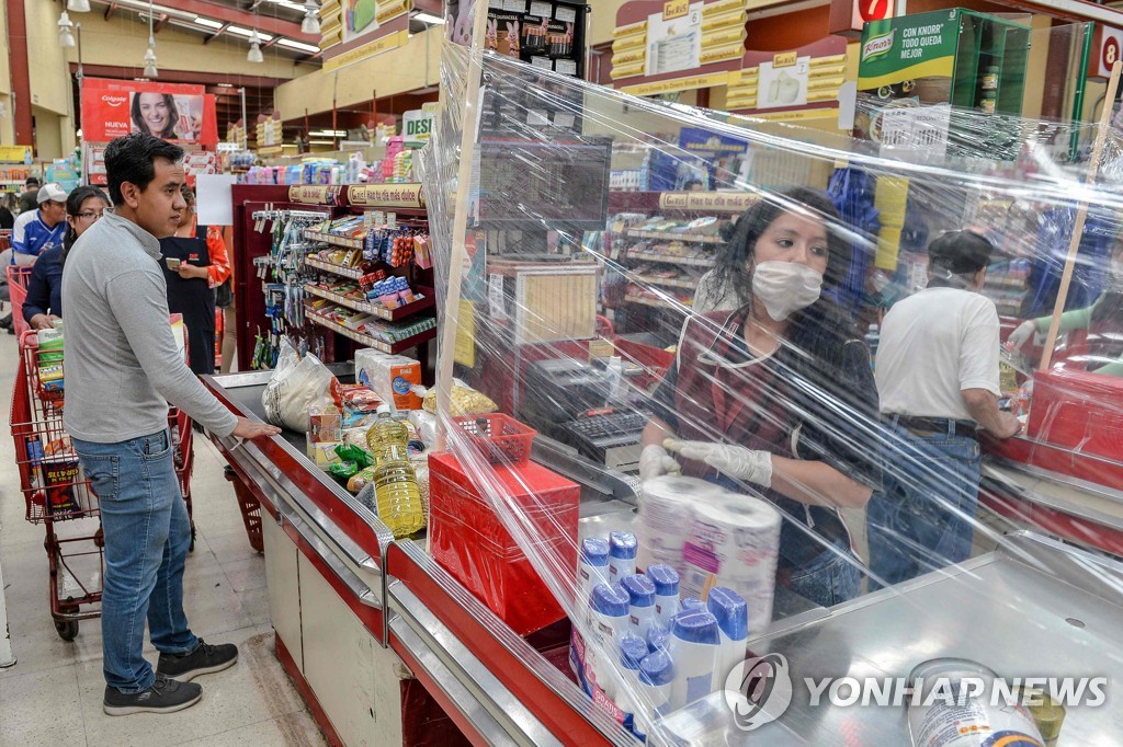 멕시코 슈퍼마켓에서 비닐 막을 치고 있는 계산원