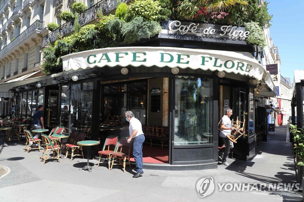 지난달 29일 프랑스 파리의 번화가인 생제르맹데프레 거리에 있는 유서깊은 카페 '카페 드 플로르'의 직원들이 개점 준비를 하고 있다. [AFP=연합뉴스 자료사진]