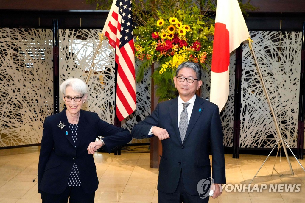 US Deputy Secretary of State Wendy Sherman (L) and Japanese Vice Foreign Minister Takeo Mori are seen bumping elbows while posing for a photo before their talks in Tokyo on Jan. 20, 2021, in this pool photo by AFP. (Yonhap)