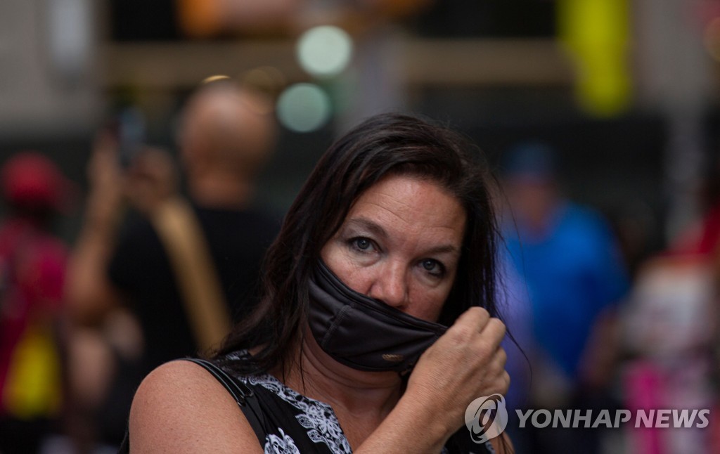 29일(현지시간) 미국 뉴욕의 한 여성이 마스크를 착용하고 있다. [AFP=연합뉴스]