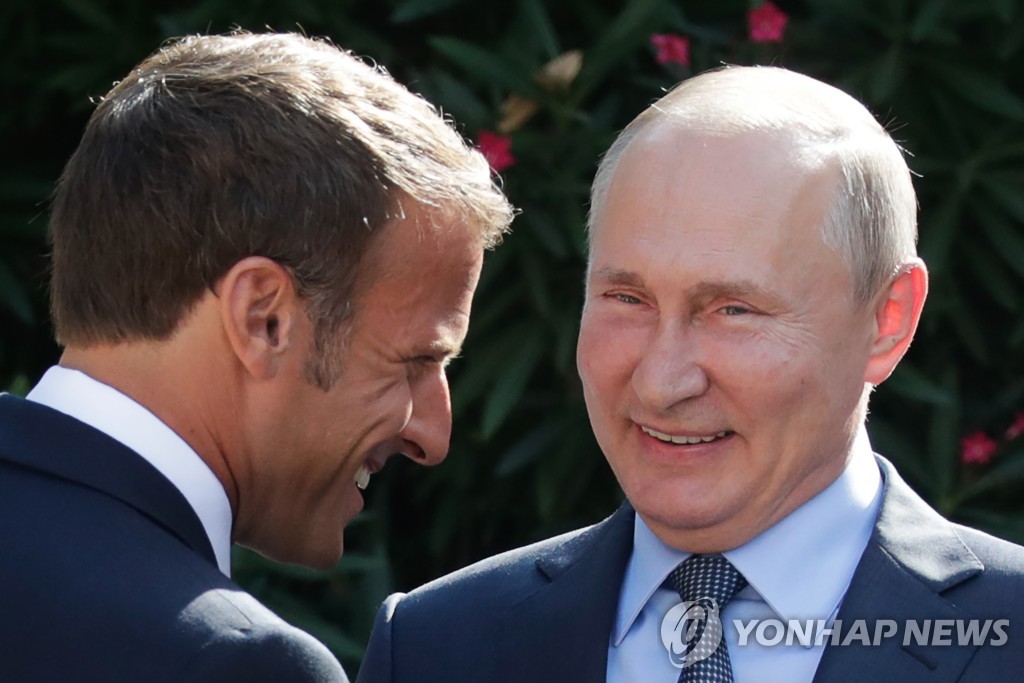 지난 달 19일 단독정상회담에서 만나 웃고 있는 에마뉘엘 마크롱 프랑스 대통령(왼쪽)과 블라디미르 푸틴 러시아 대통령[타스=연합뉴스]