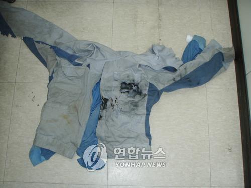 휴대전화 폭발로 검게 그을린 작업복