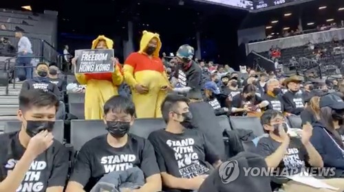 18일 농구경기 도중 곰돌이 푸 복장을 하거나 홍콩 지지 문구가 써진 티셔츠를 입고 시위를 벌이는 관중들