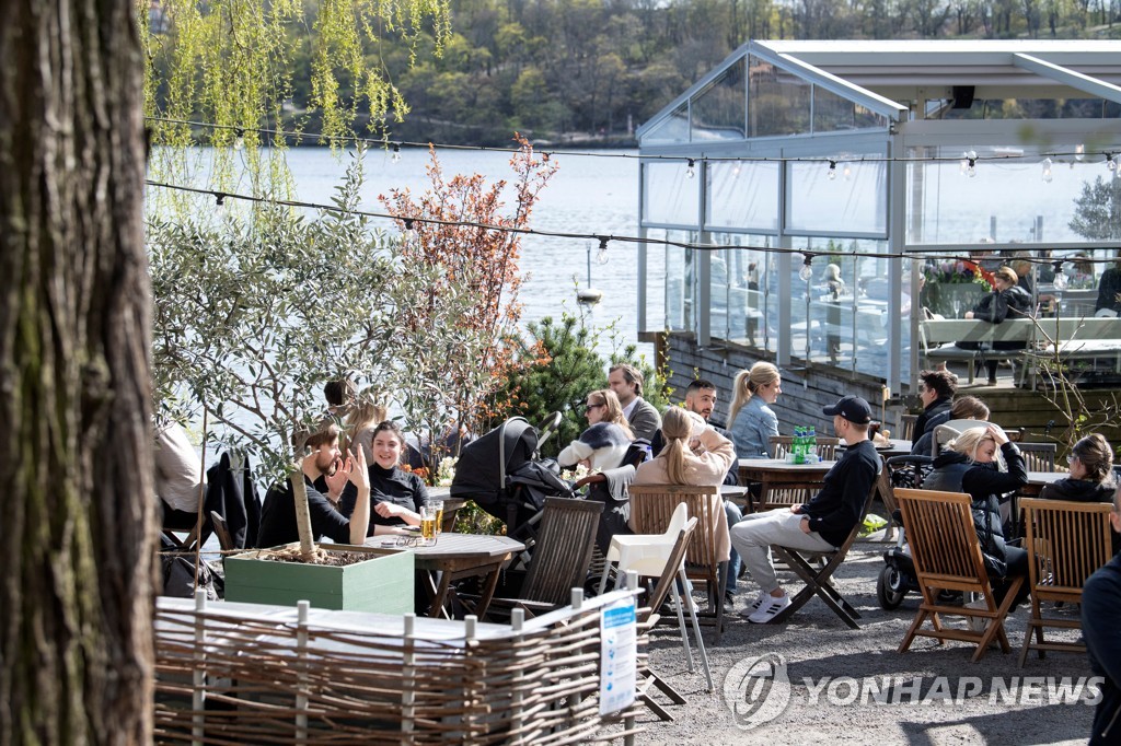 26일 스페인 스톡홀름의 야외 카페에 모인 시민들의 모습. [제시카 고우·TT통신·로이터=연합뉴스]