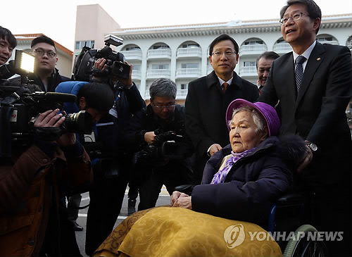 류길재 통일부 장관이 동생들을 만나러가는 최정호(91)할머니의 휠체어를 밀어주고 있다.