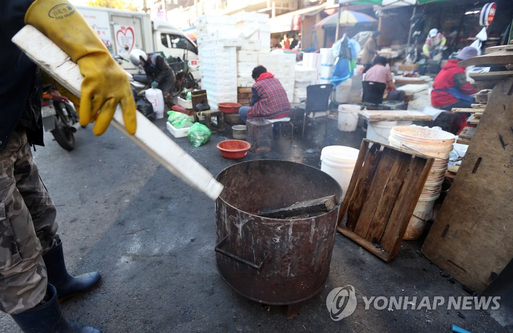 서울의 한 전통시장 상인들이 모닥불을 피워둔 채 일을 하고 있다. (연합뉴스 자료사진)