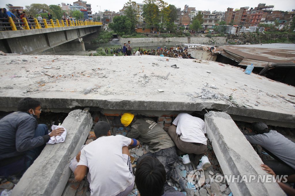 네팔 지진현장에 진출한 국내 건설사들 "큰 피해 없는 것으로 알려졌다. 사진은 카트만두의 붕괴된 건물 잔해 밑에서 구조작업하는 모습.(카트만두 AP=연합뉴스)