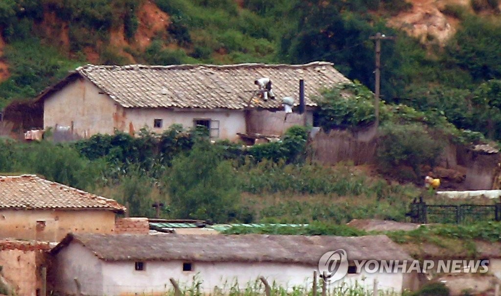 북한군이 준전시상태 명령을 해제한 지 하루가 지난 지난 26일 오전 인천시 강화군 양사면 제적봉 평화전망대에서 바라본 북한 개풍군 당두포리. 북한 주민들이 지붕위에 옥수수를 말리고 있다. (연합뉴스 자료사진)