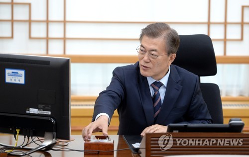 지난 12일 취임 후 두 번째 업무지시를 통해 국정역사교과서를 폐기하고 제37주년 5·18 기념식에서 '님을 위한 행진곡'을 제창할 것을 지시하는 전자결재를 하기 위해 전자카드로 컴퓨터 인증을 받고 있는 문재인 대통령