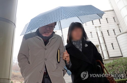 우산으로 얼굴 가리는 김문환 전 대사