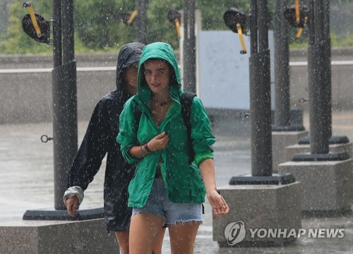 비 내리는 서울도심을 걷는 외국인