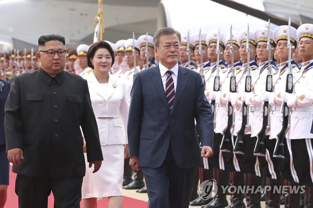 South Korean President Moon Jae-in (R) and North Korea's top leader, Kim Jong-un, review an honor guard at a welcoming ceremony for Moon at Pyongyang International Airport on Sept. 18, 2018. Moon arrived on the day for a three-day visit to North Korea for his third summit with Kim. (Pool photo) (Yonhap)