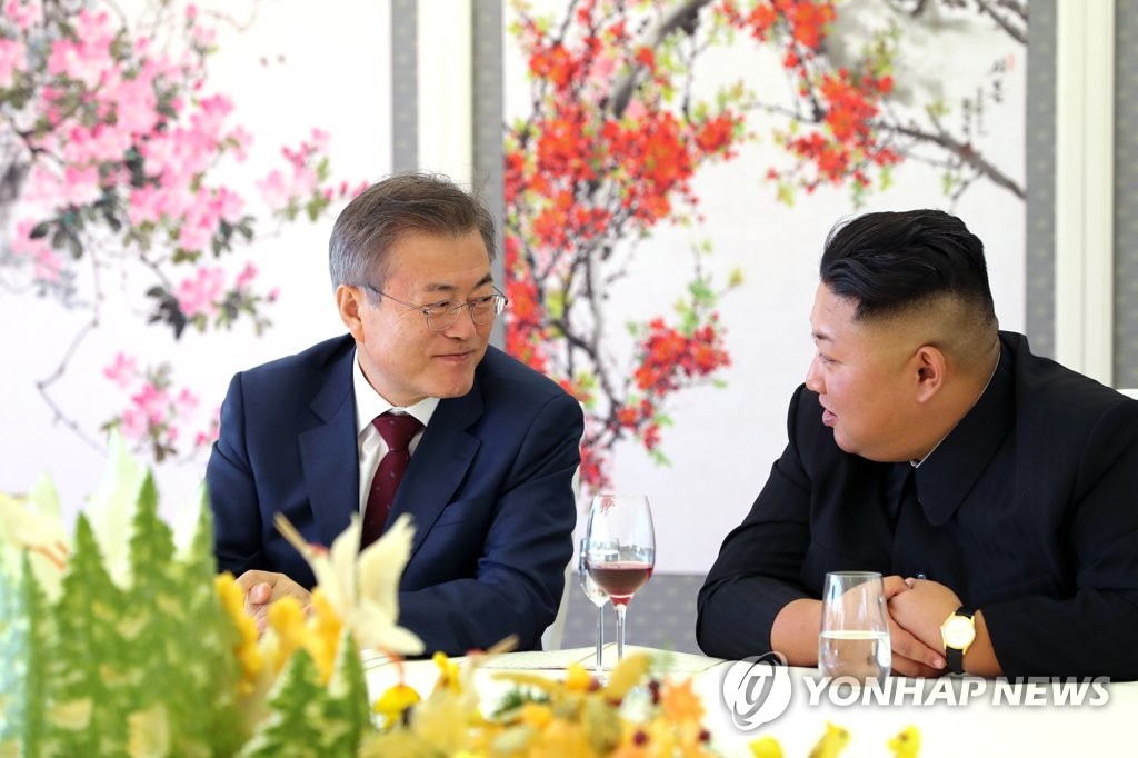 South Korean President Moon Jae-in (L) and North Korean leader Kim Jong-un chat during a luncheon at a guesthouse at Lake Samji near the North's northern border on Sept. 20, 2018. Moon ended his three-day visit to North Korea with an excursion to Mount Paekdu, the tallest mountain on the Korean Peninsula, with Kim. The leaders agreed during their summit talks on a wide range of steps to ease cross-border tensions. (Pool photo) (Yonhap)