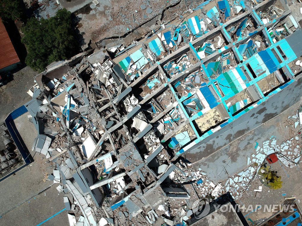(팔루<인도네시아> AFP=연합뉴스) 28일(현지시간) 인도네시아 술라웨시 섬에서 발생한 강진과 이어진 쓰나미로 인해 무너진 팔루의 한 호텔 잔햇더미 아래 수십 명이 갇혀 있는 것으로 파악됐다. 또 동갈라 지역은 팔루보다 진앙지에 더 가까우며 30만명 이상이 살고 있는 것으로 알려져 희생자는 크게 늘어날 것으로 예상됐다. 사진은 이번 지진으로 무너진 팔루의 10층 호텔 건물이 이날 폭격을 받은 듯 파괴된 모습. bulls@yna.co.kr(끝)