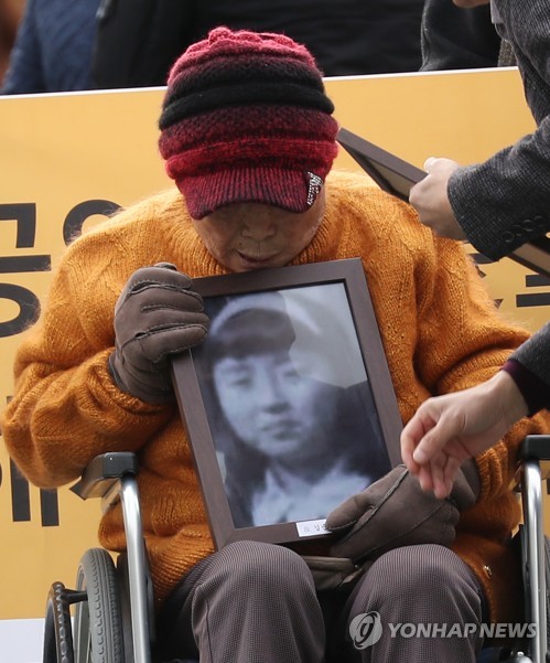 동료의 영정을 들고서