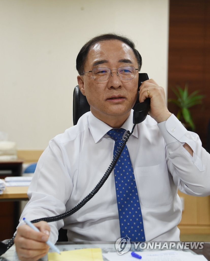 This photo provided by the finance ministry on Dec. 18, 2018, shows Finance Minister Hong Nam-ki on the phone in his Seoul office with U.S. Treasury Secretary Steven Mnuchin. (Yonhap)