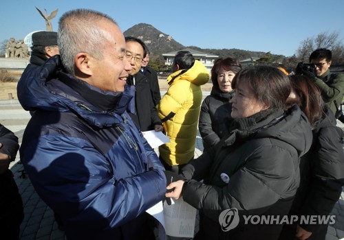 자식을 가슴에 묻은 아버지와 어머니의 악수