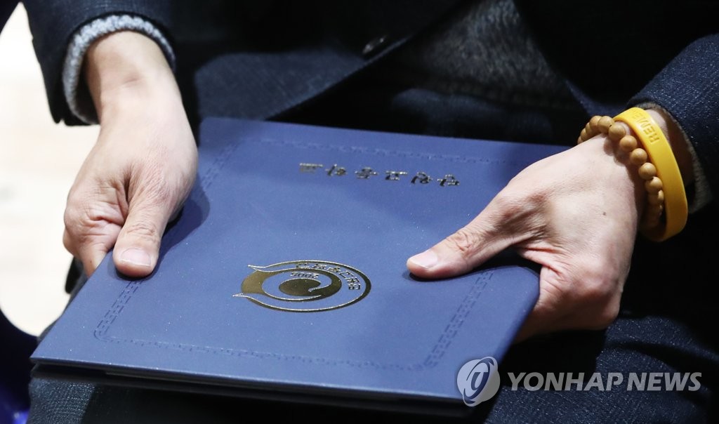 손에 꼭 쥔 졸업장