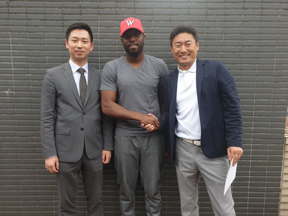 In this photo provided by the SK Wyverns baseball club on June 3, 2019, Henry Sosa (C) shakes hands with a team official after signing with the Korea Baseball Organization club. (PHOTO NOT FOR SALE) (Yonhap)