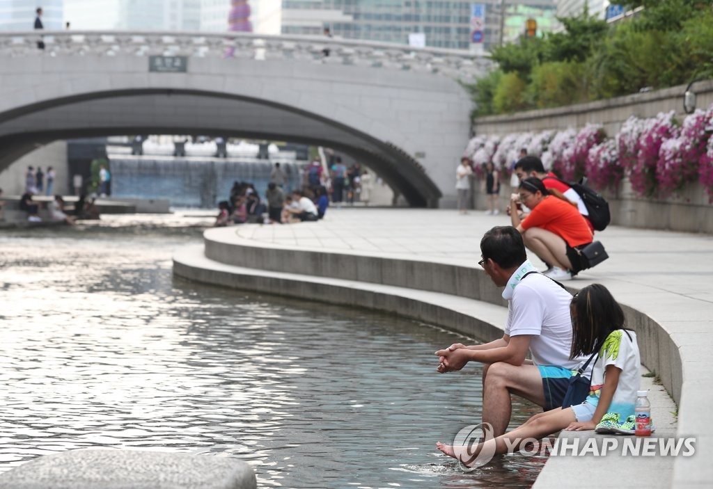 People relax along Cheonggye Stream People relax along Cheonggye Stream