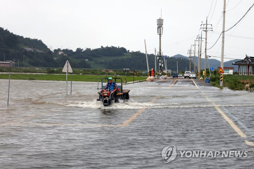 물에 잠긴 도로를 지나는 경운기