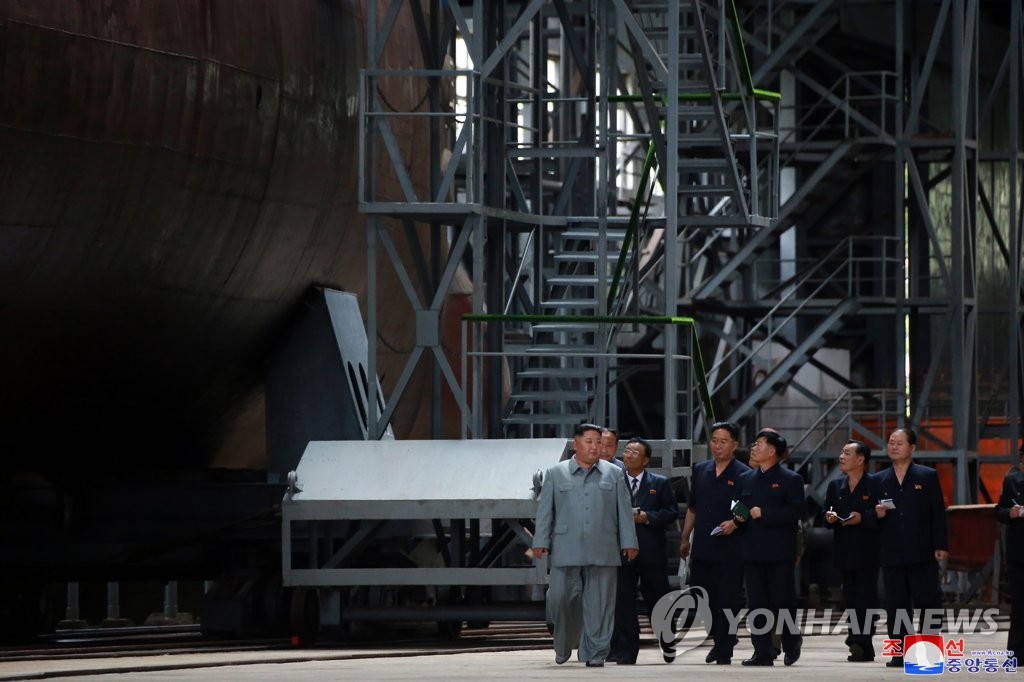 In this photo, released by the Korean Central News Agency on July 23, 2019, North Korean leader Kim Jong-un (L) inspects a new submarine. The agency didn't provide the date or location. (For Use Only in the Republic of Korea. No Redistribution) (Yonhap)