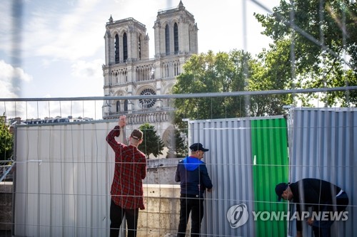 (파리 EPA=연합뉴스) 지난 4월 대형화재로 골조에 쓰인 납이 대거 녹아내린 프랑스 파리 노트르담 대성당과 인근 지역에 대한 본격적인 납 제거 작업이 13일(현지시간) 시작돼 작업자들이 성당 주변에 안전을 위한 보호장벽을 세우고 있다.