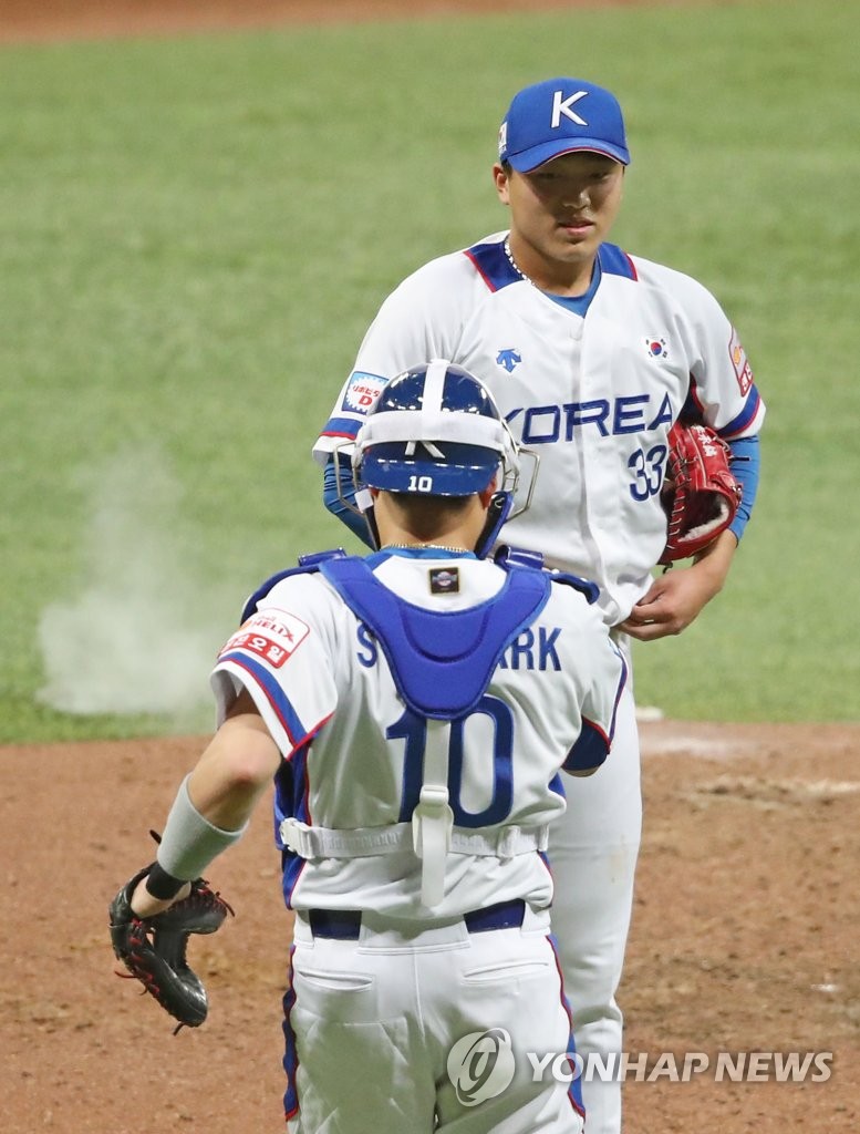 In this file photo from Nov. 8, 2019, Lee Seung-ho of South Korea (above) shakes hands with his catcher Park Sei-hyook after completing the final out of a 7-0 win over Cuba in the teams' Group C game at the World Baseball Softball Confederation (WBSC) Premier12 at Gocheok Sky Dome in Seoul. (Yonhap)