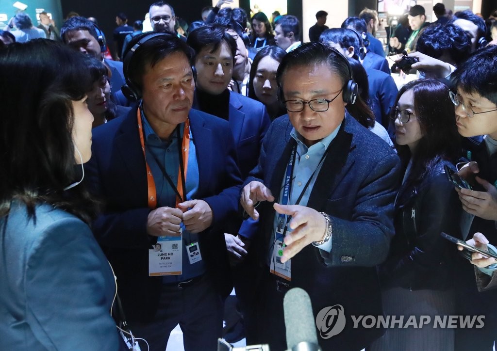 Koh Dong-jin (R), President and CEO of Samsung's IT & Mobile Communication division, explains the company's products to SK Telecom CEO Park Jung-ho at Samsung booth at Consumer Electronics Show (CES) 2020 in Las Vegas on Jan. 7, 2020. (Yonhap)