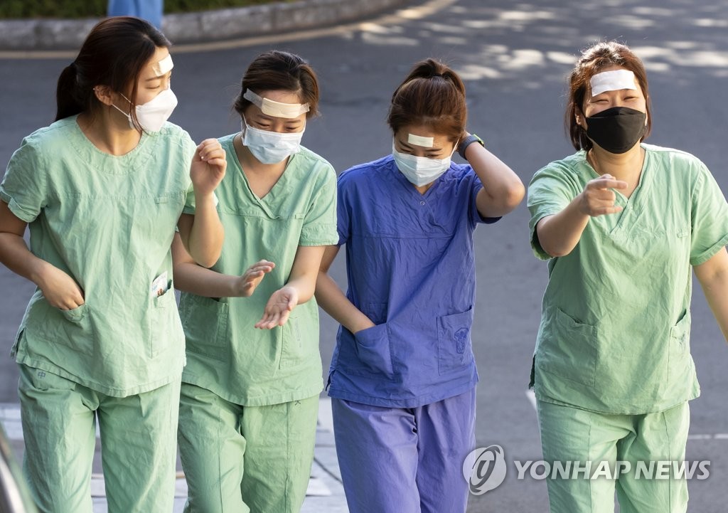 Medical staffers walk to a staff lounge after finishing a shift at Dongsan Hospital in coronavirus-hit Daegu, 302 kilometers southeast of Seoul, on March 11, 2020. (Yonhap)