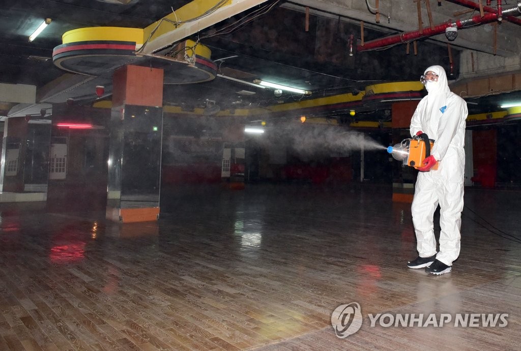This photo, provided by the office of the Busanjin Ward in the southeastern city of Busan on March 19, 2020, shows a quarantine official disinfecting an alcohol-free dance club over the new coronavirus. (PHOTO NOT FOR SALE) (Yonhap)