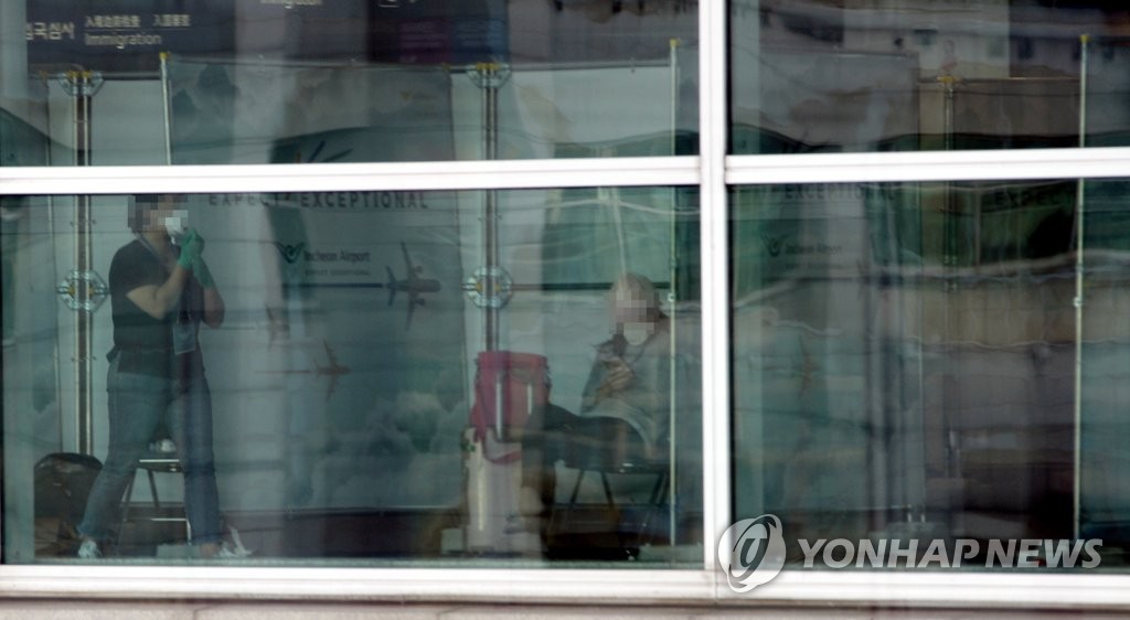 韓国の検疫当局は欧州からの入国者全員にウイルス検査を行っている。仁川国際空港に設置された検査用の診療所で待機する旅行客＝２３日、仁川（聯合ニュース）