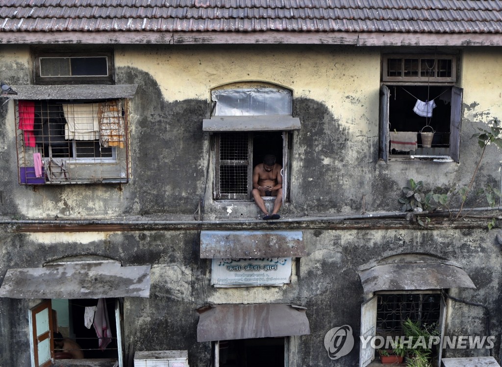 코로나19 봉쇄령으로 창턱에 걸터앉은 인도 주민