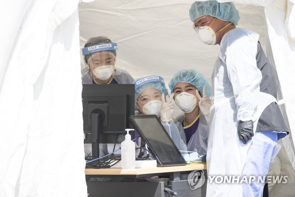 Health workers clad in protective suits pose for a photo at Seoul Medical Center in Seoul on April 28, 2020. (Yonhap)