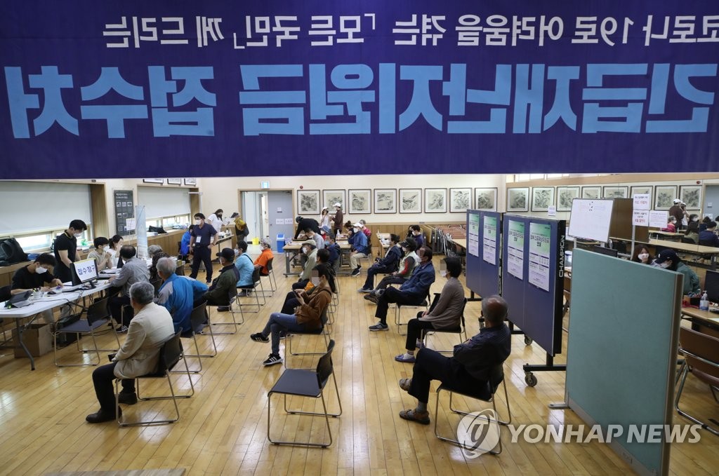 Residents wait while keeping a distance from each other to apply for emergency disaster relief funds at a community center in Seoul on May 18, 2020. The state funds for everyone in the country are designed to help activate the economy, especially small business sectors, amid the coronavirus crisis. (Yonhap)