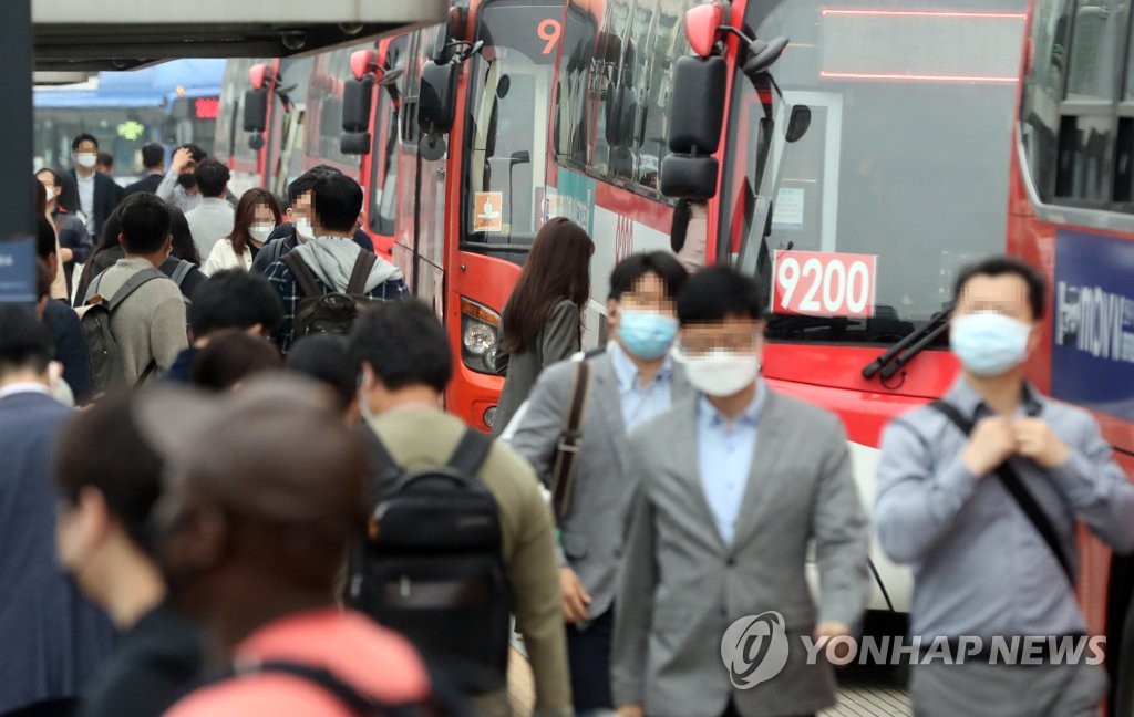 新型コロナウイルスの感染防止のため韓国では５月から、マスクを着用していない人はバスやタクシーなどの公共交通機関の利用が制限されている。ソウル駅前のバス乗り場を行き交うマスク姿の市民＝（聯合ニュース）