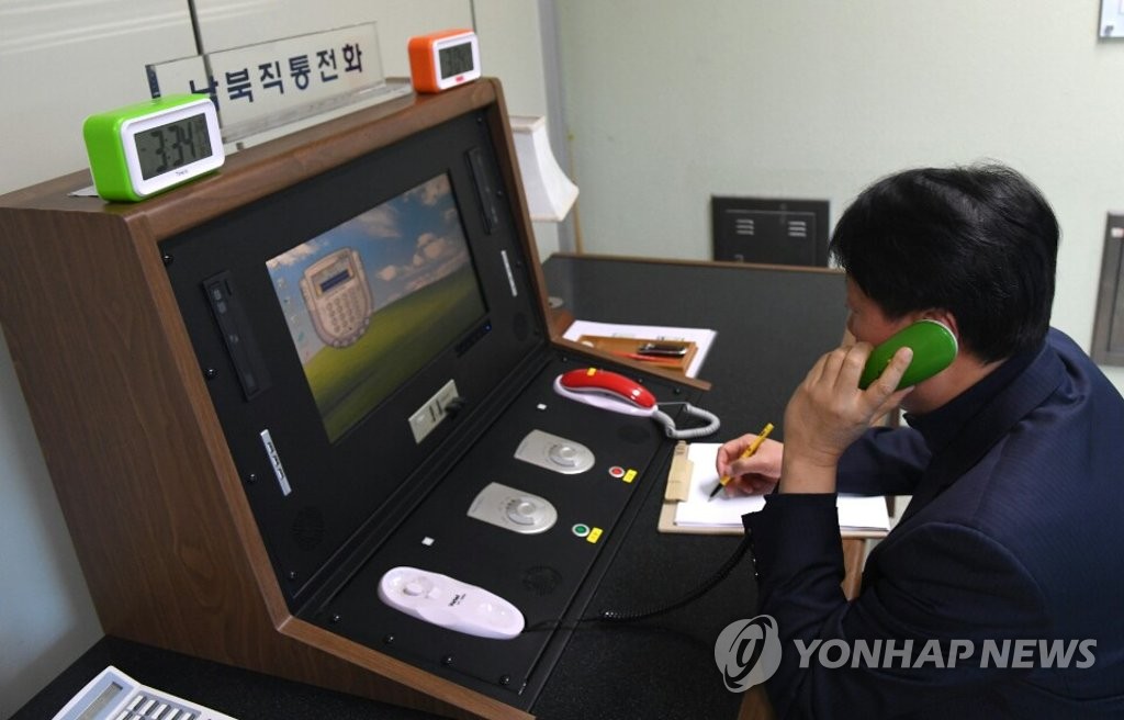This file photo shows a South Korean official making a test call with North Korea via a hotline on Jan. 1, 2018, set up at an inter-Korean liaison office in the truce village of Panmunjom. On June 9, 2020, North Korea announced its decision to disconnect all inter-Korean communications lines, including the hotline, at noon, citing anti-Pyongyang leaflets recently sent via balloons by North Korean defectors across the border. (Yonhap)