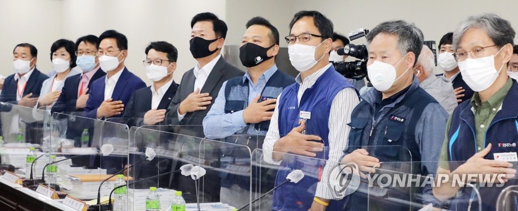 최저임금위원회에서 국기에 경례하는 위원들